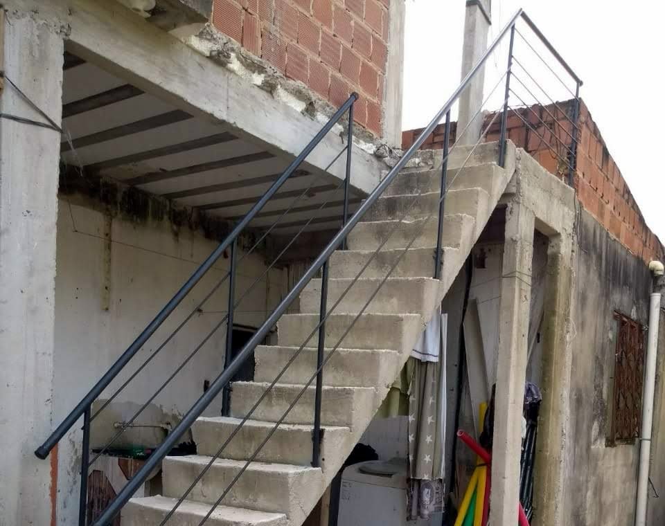 Corrimão de ferro instalado em escada de concreto externa